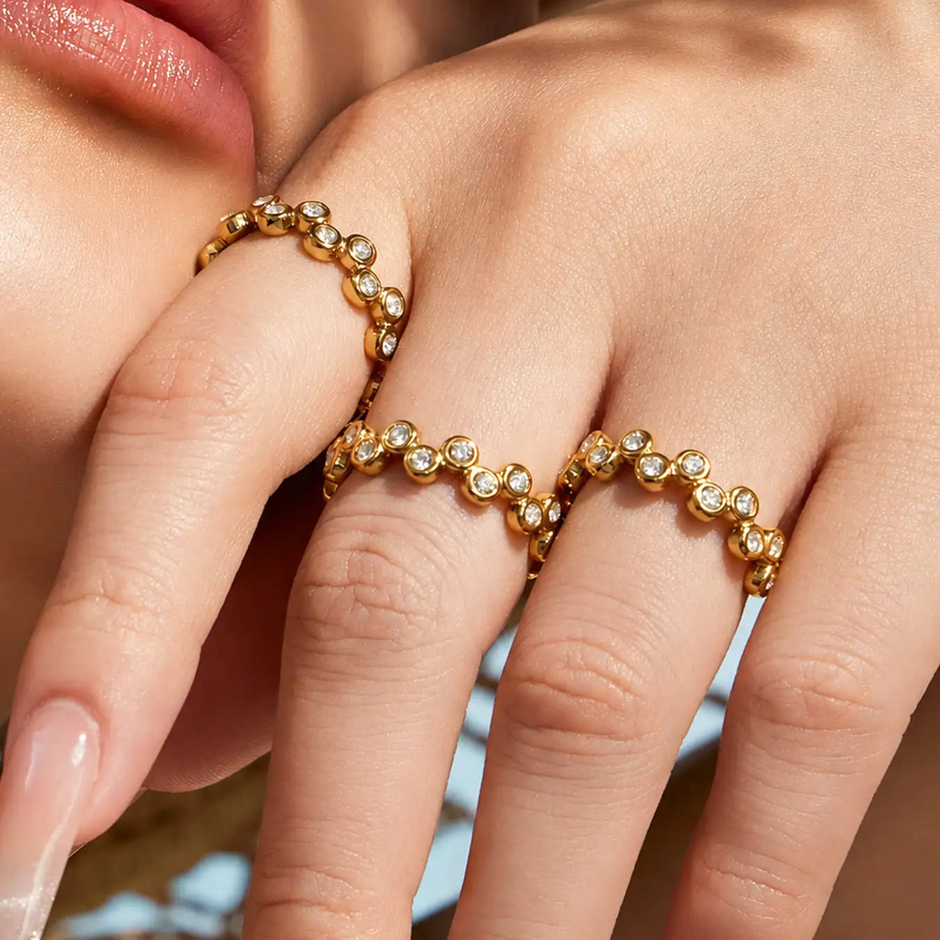 Gold-toned ring with a delicate, beaded design featuring evenly spaced round-cut clear stones.
