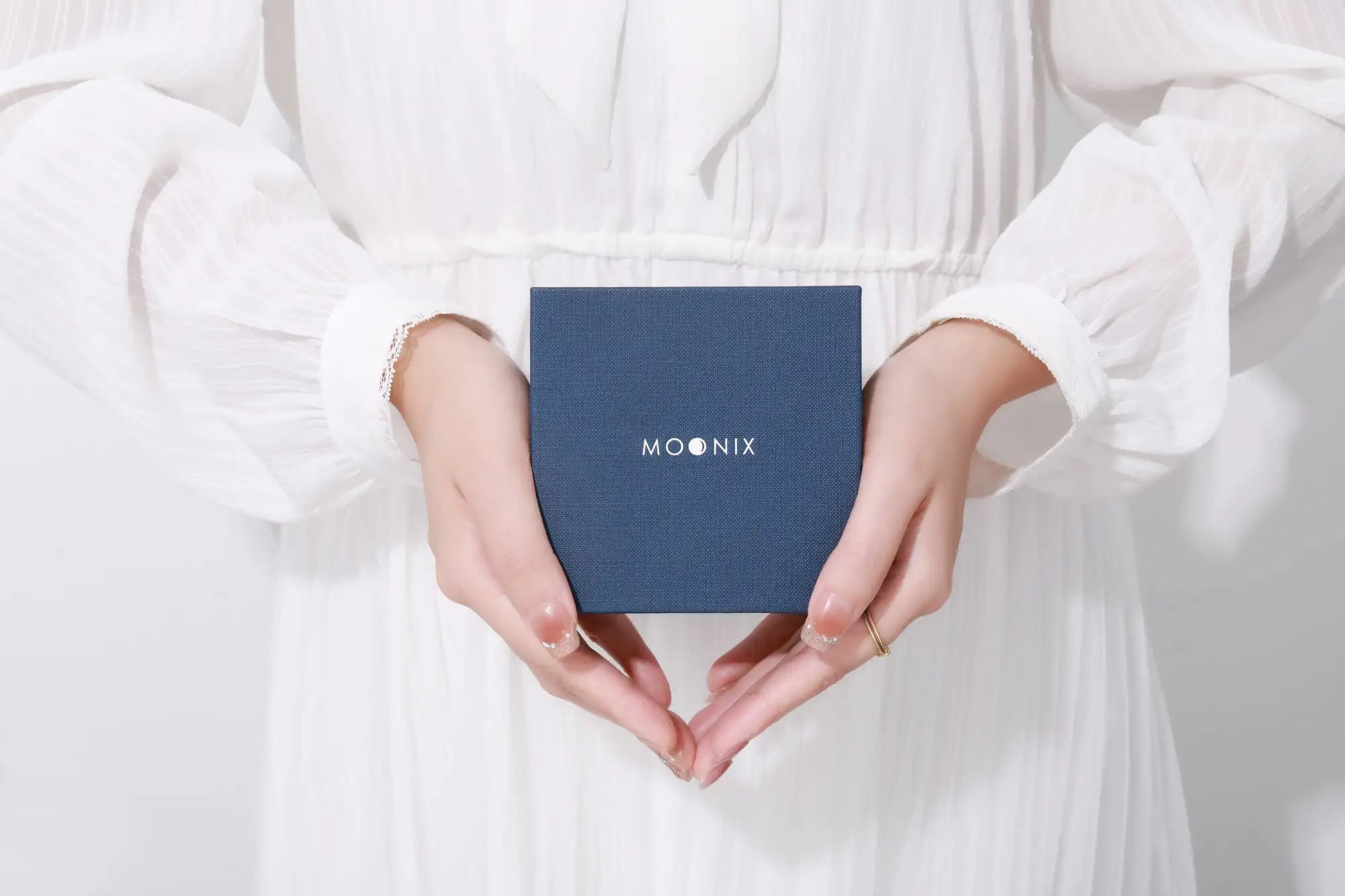 A navy blue textured square box with the ’moonix’ logo in white lettering.