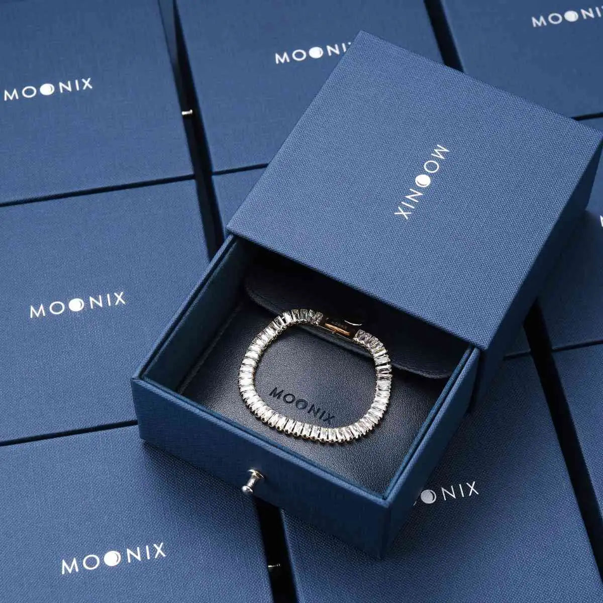 A sleek silver-toned bracelet with a continuous line of sparkling, faceted stones set in an elegant, modern design.
